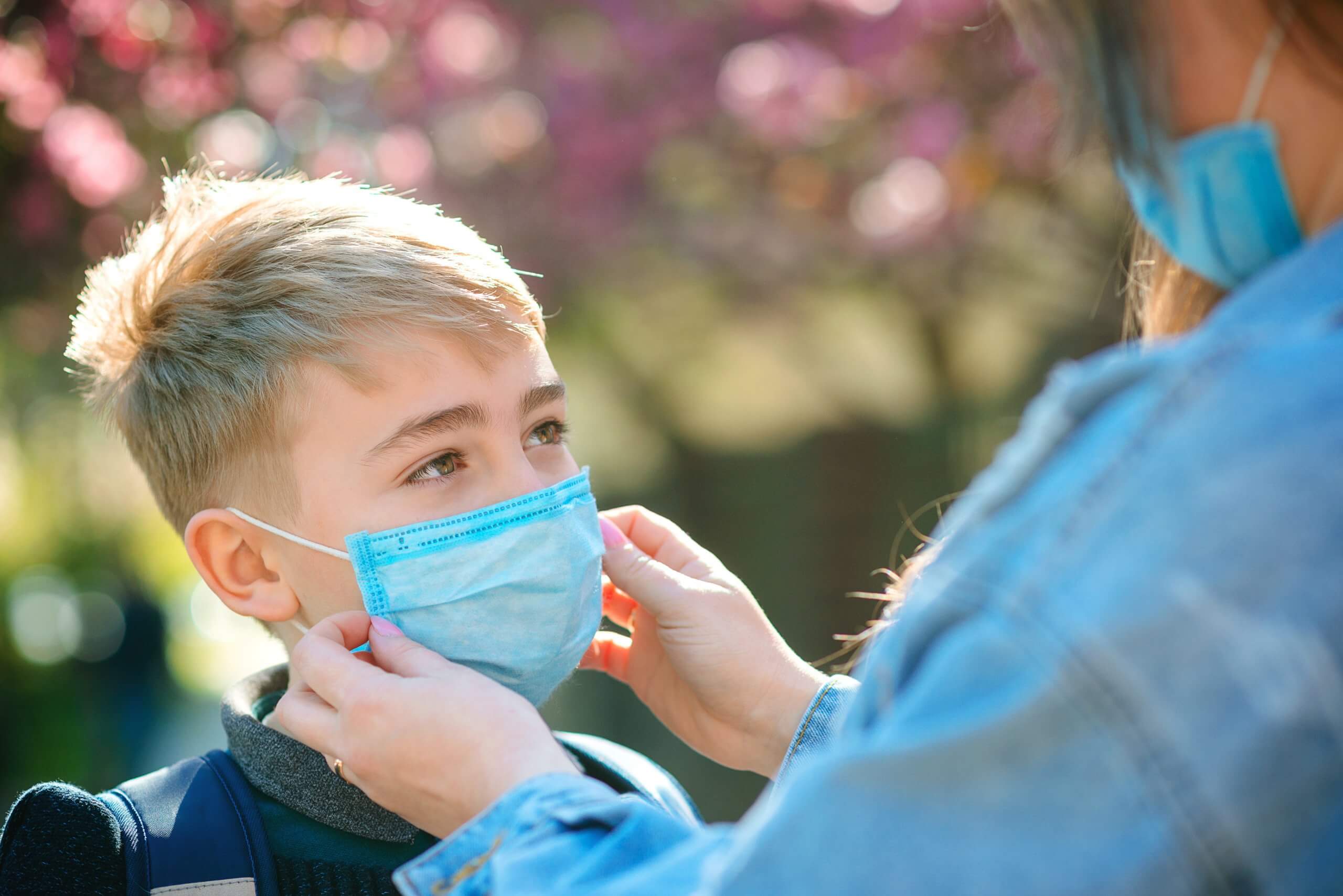 Mother Puts Her Son A Face Protective Mask Outdoors. Coronavirus