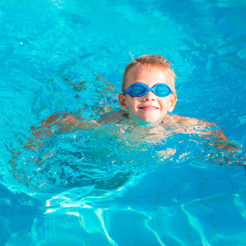 Cute Happy Little Boy In Goggles Swimming