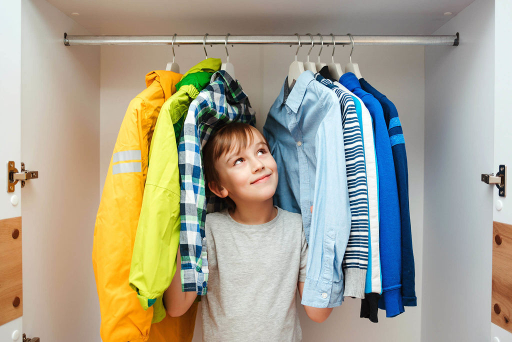 Preteen Boy Chooses Clothes In The Wardrobe Closet At Home. Kid