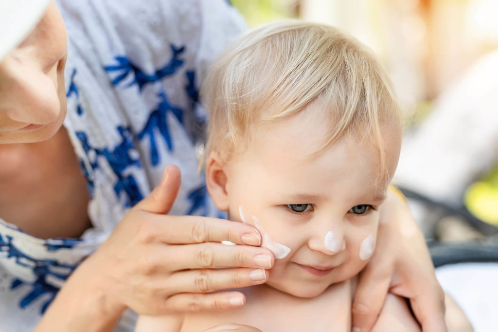 Mother Applying Sunscreen Protection Creme On Cute Little Toddle