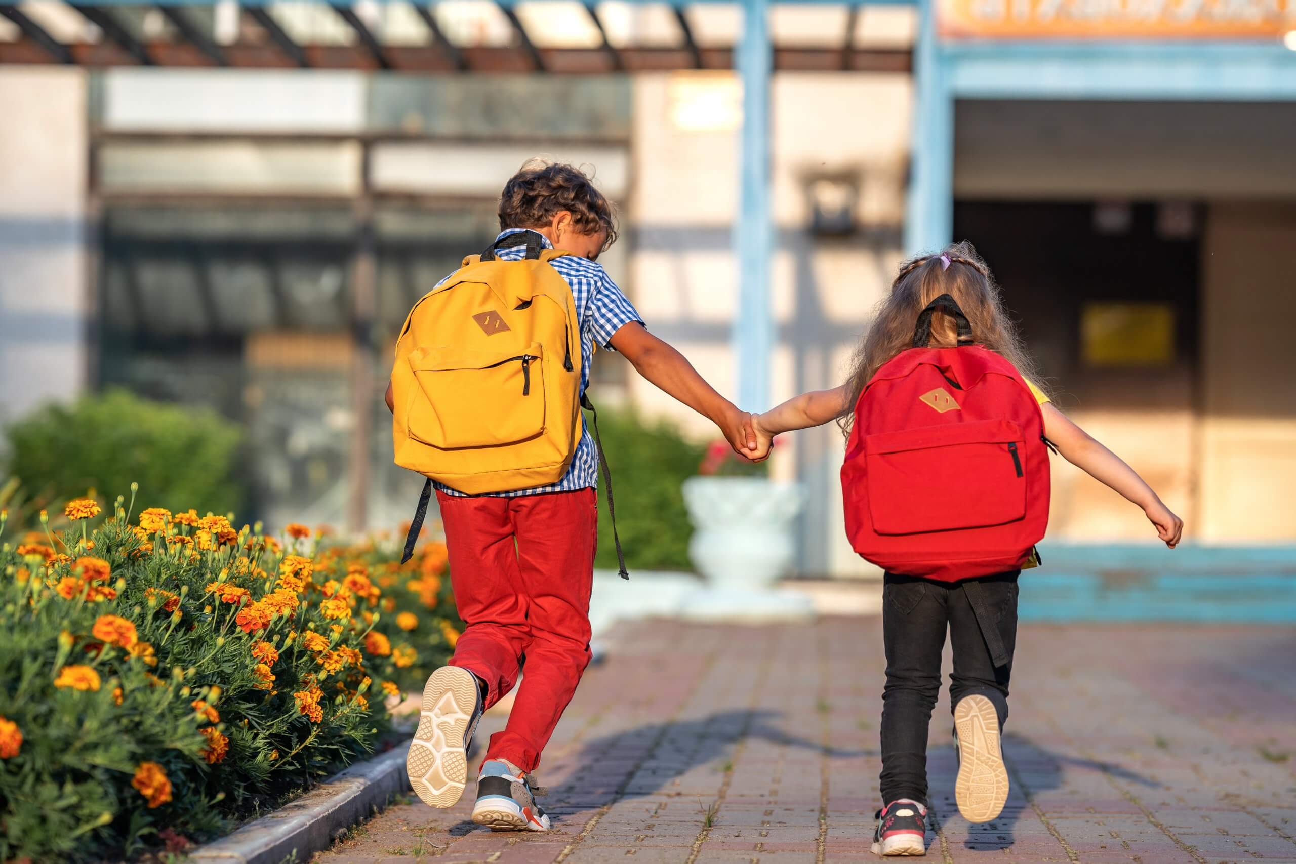 Primary School Pupil. Boy And Girl With Backpacks Walking Down S